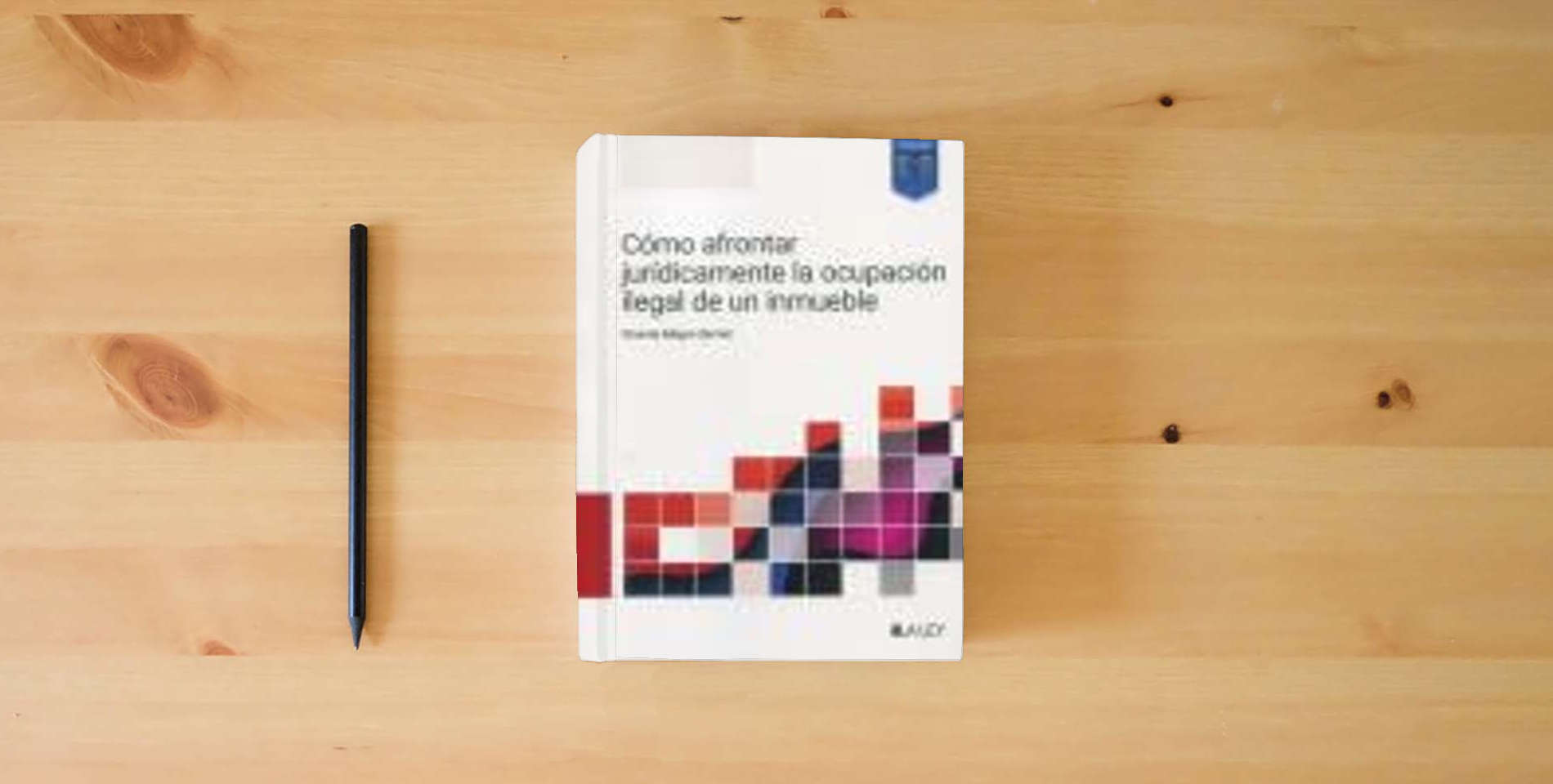 The book Cómo afrontar jurídicamente la ocupación ilegal de un inmueble is on the table
