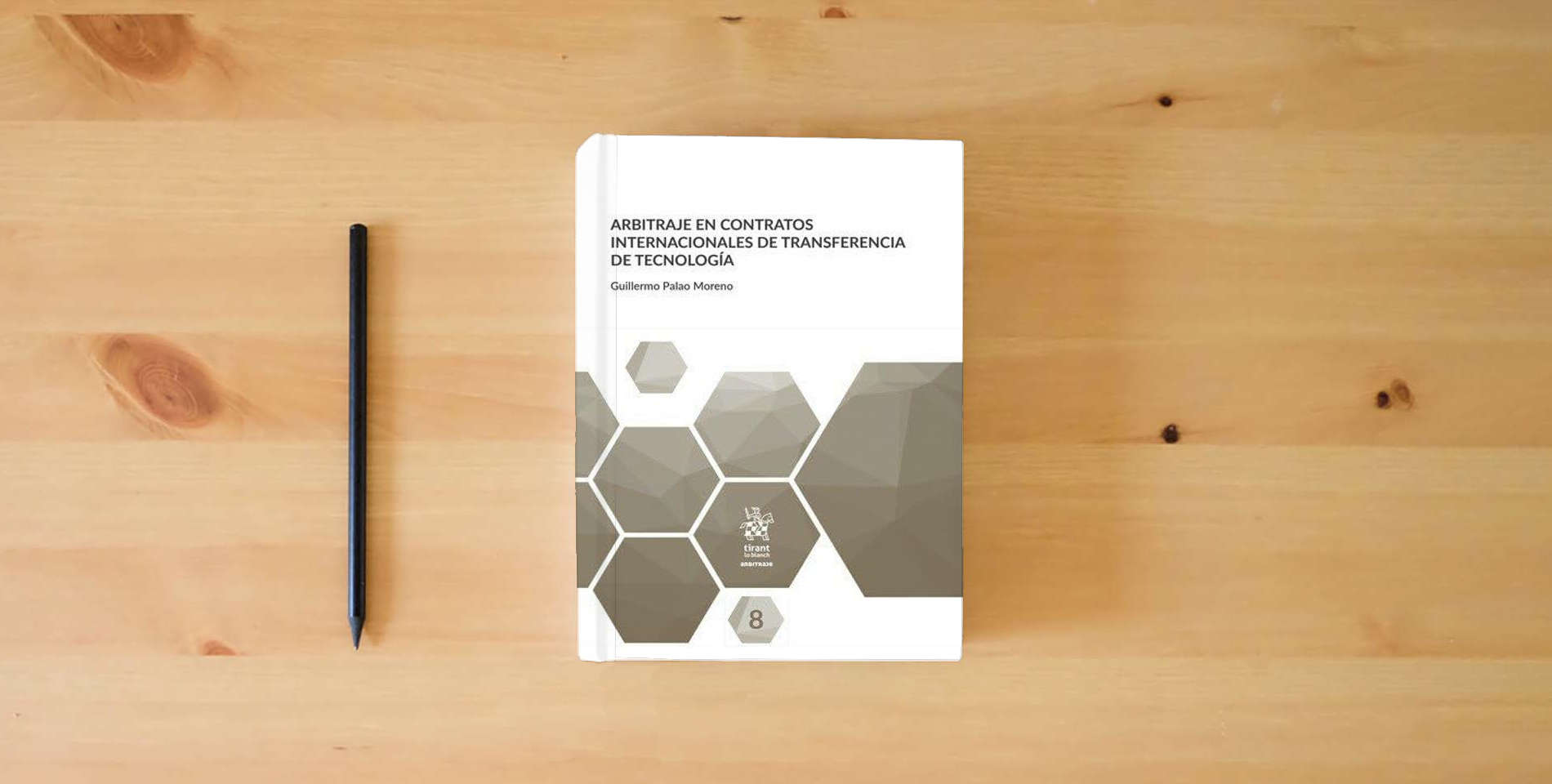 The book Arbitraje En Contratos internacionales de TRANSFERENCIA De Tecnología is on the table