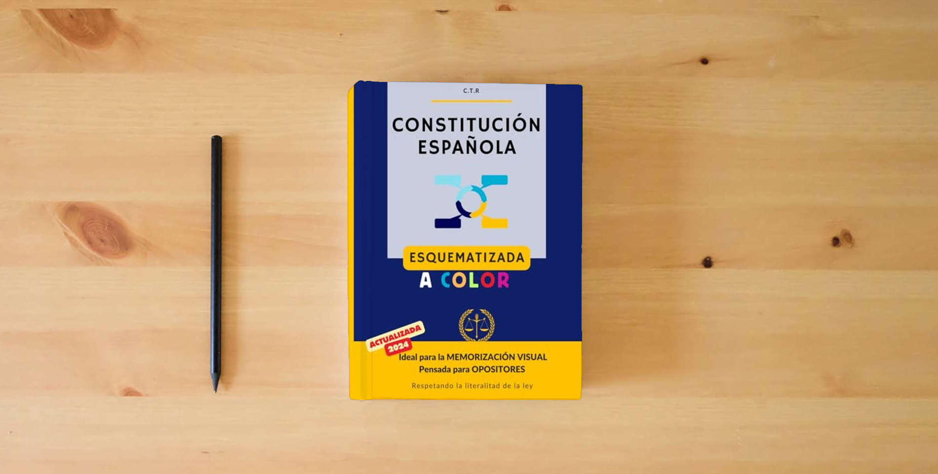 The book Constitución Española (Ilustrado): Esquematizada a color | Para Opositores | Gran formato is on the table