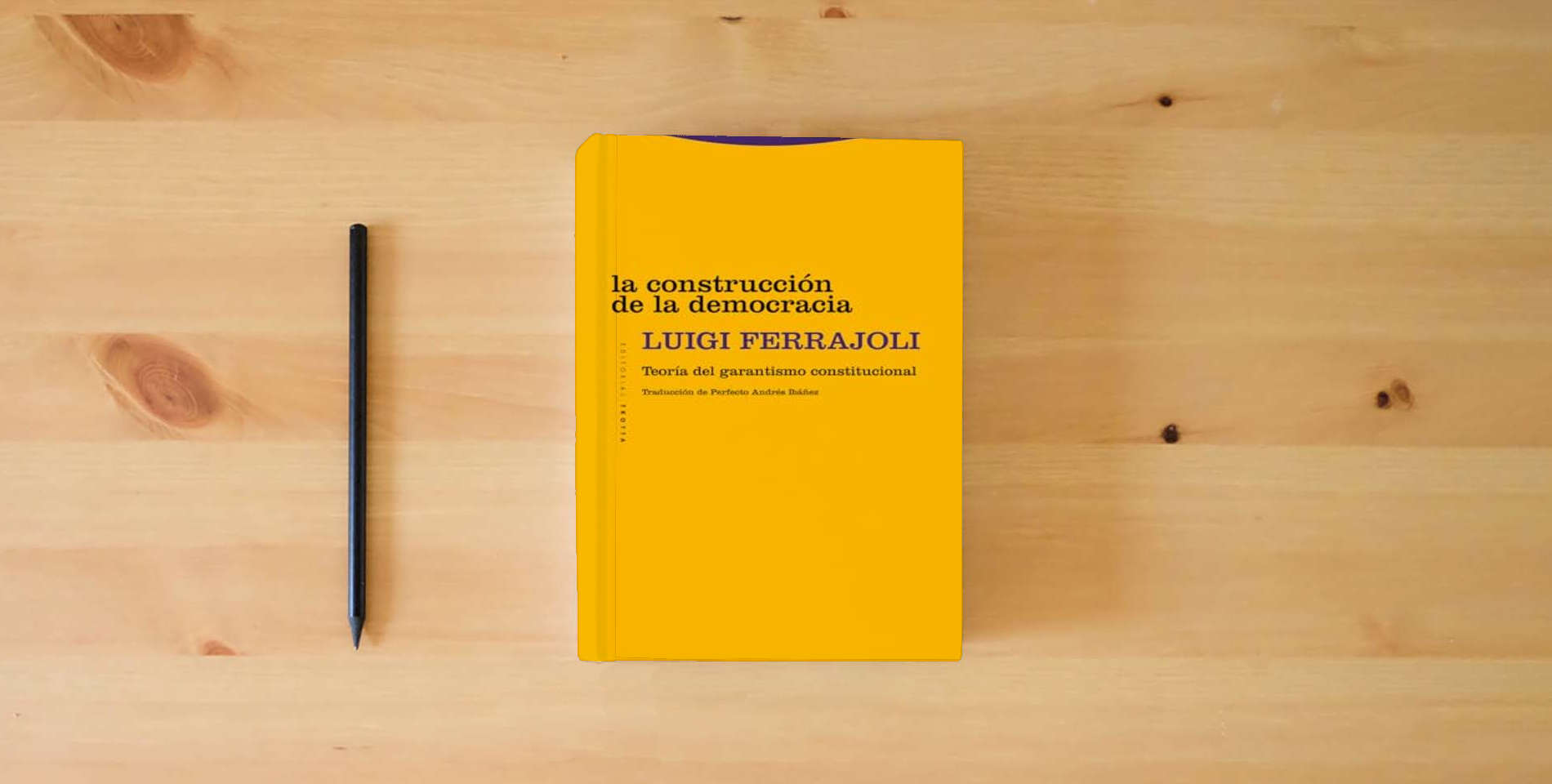 The book La construcción de la democracia: Teoría del garantismo constitucional (ESTRUCTURAS Y PROCESOS - DERECHO) is on the table