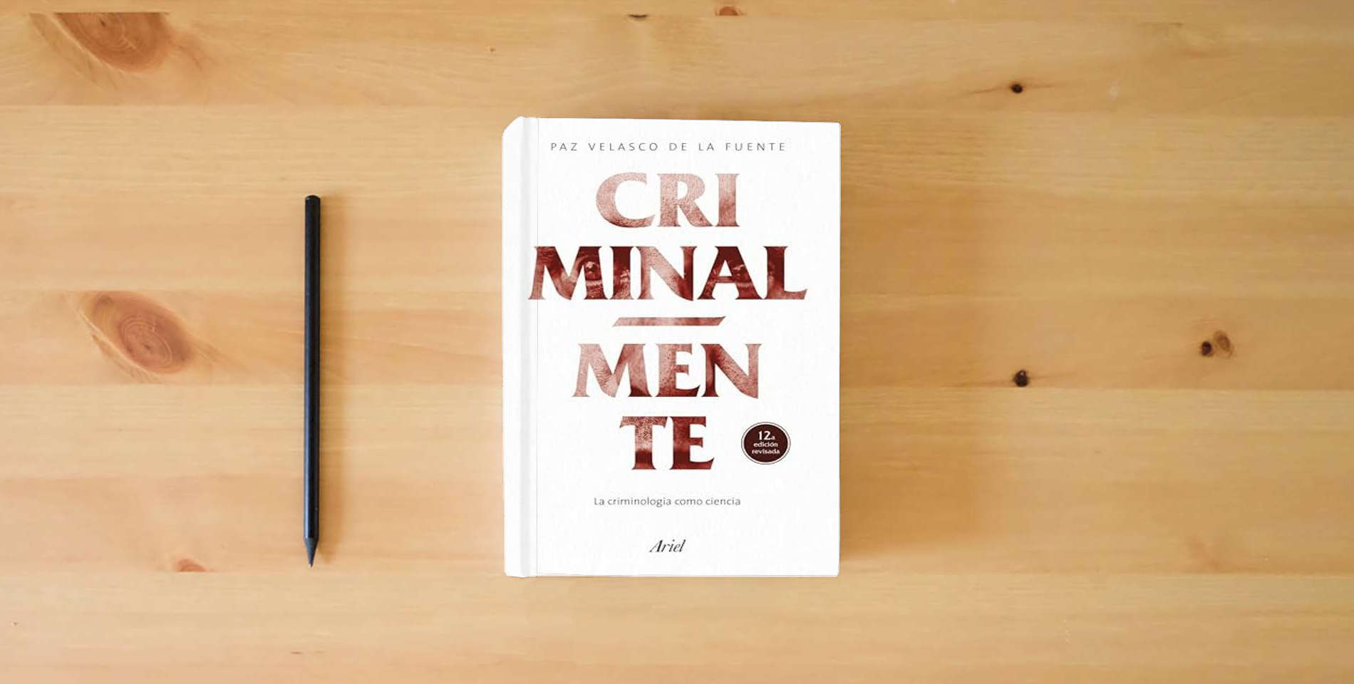 The book Criminal-mente: La criminología como ciencia (Ariel) is on the table