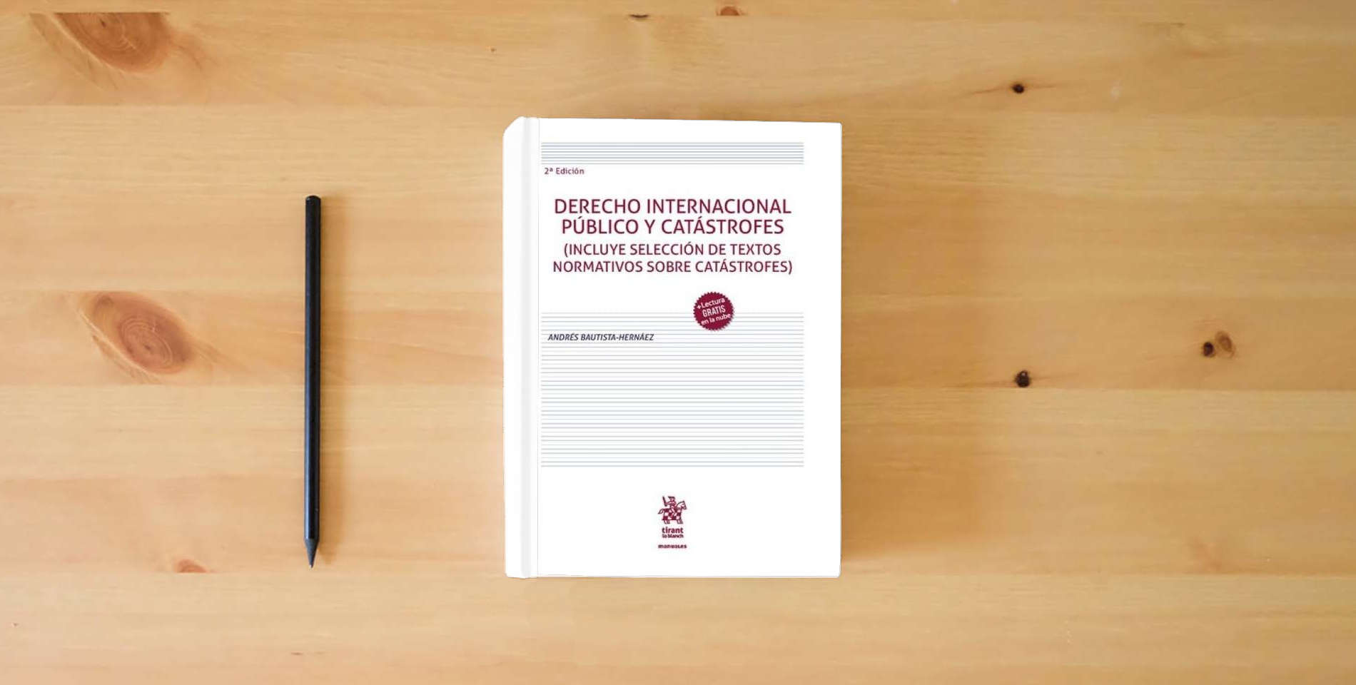 The book Derecho Internacional Público y Catástrofes 2ª Edición (Manuales) is on the table