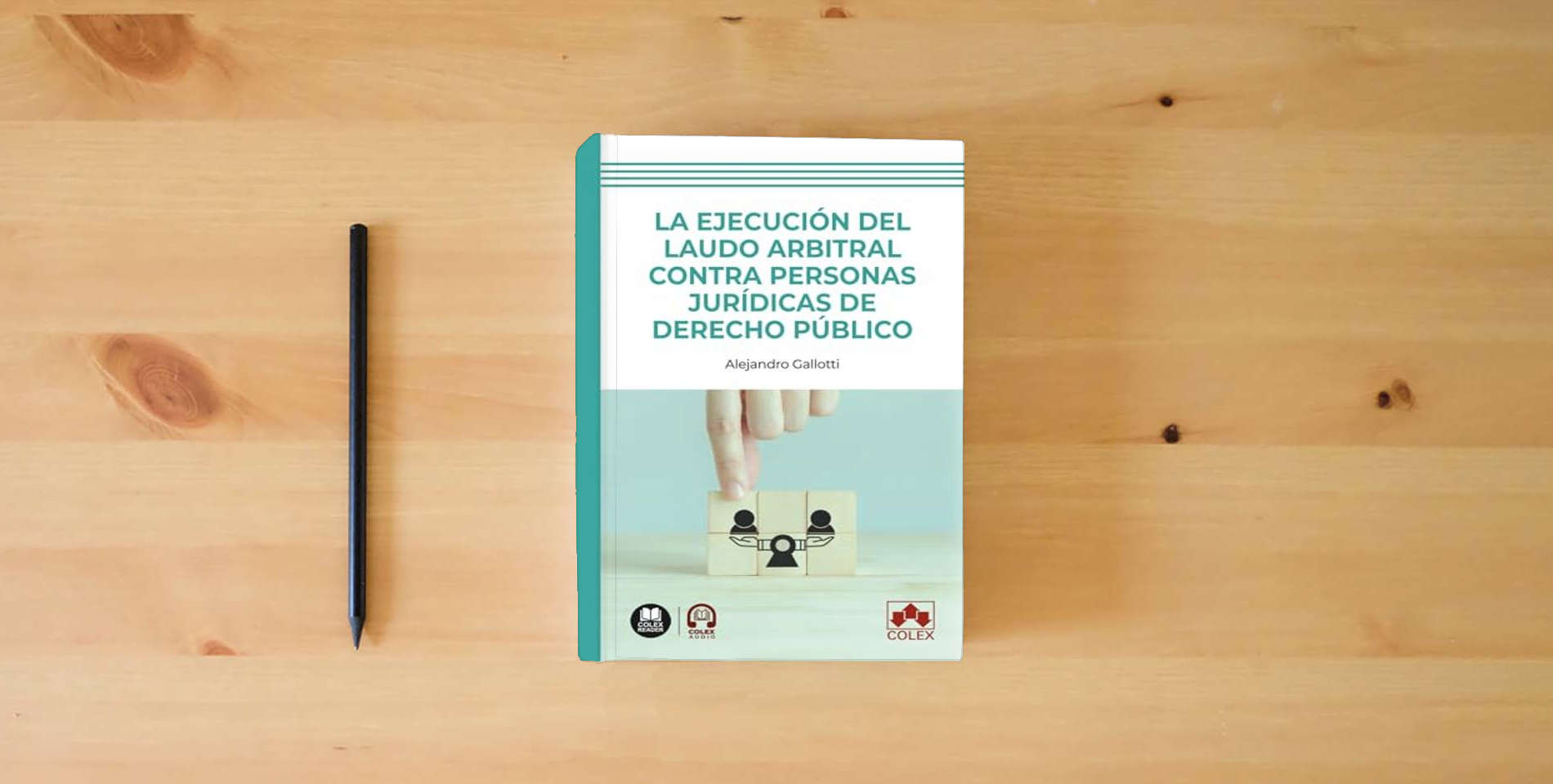 The book La ejecución del laudo arbitral contra personas jurídicas de Derecho público (monografico) is on the table