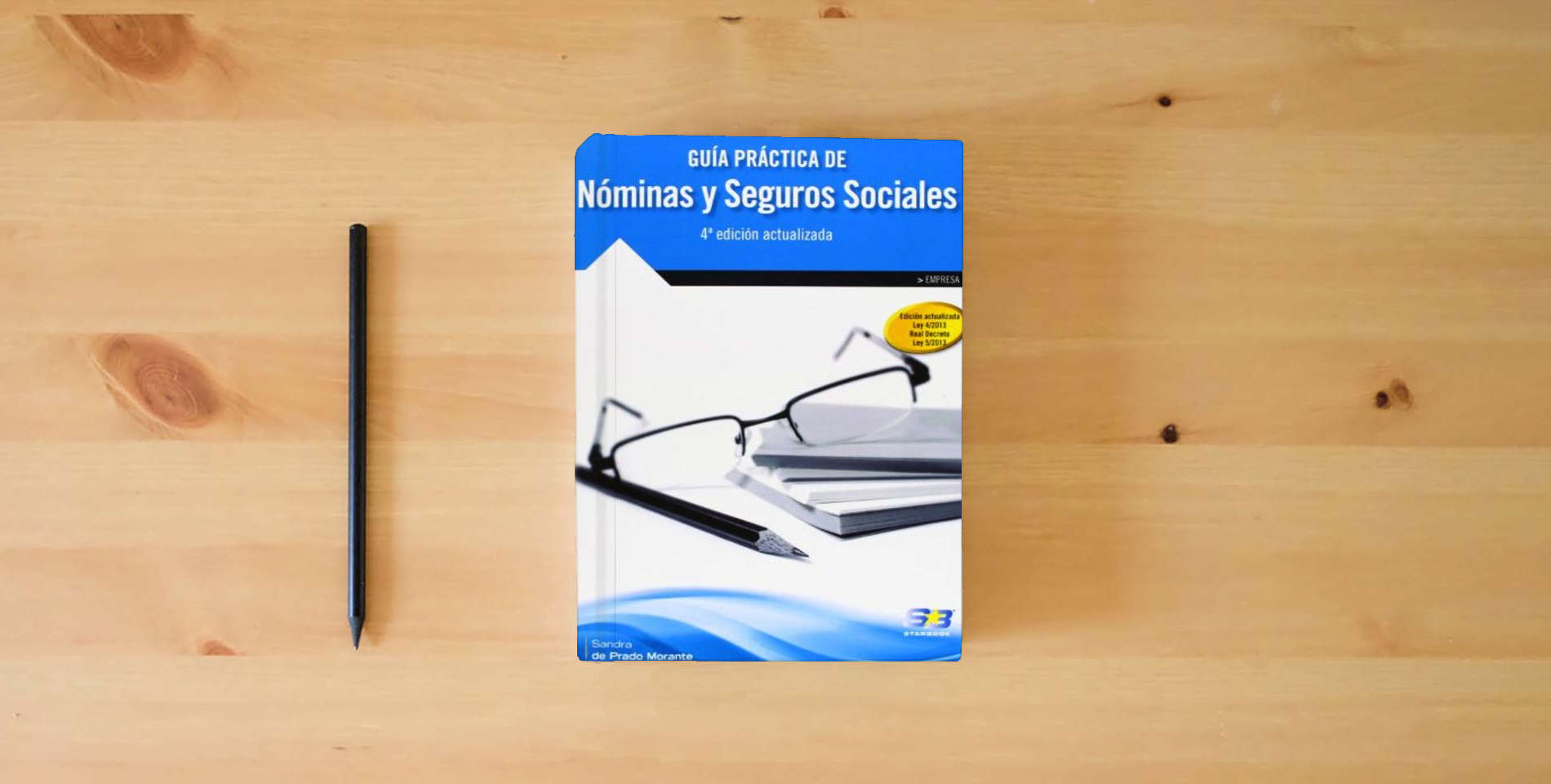 The book Guía Práctica de Nóminas y Seguros Sociales. 4ª Edición (EMPRESA) is on the table