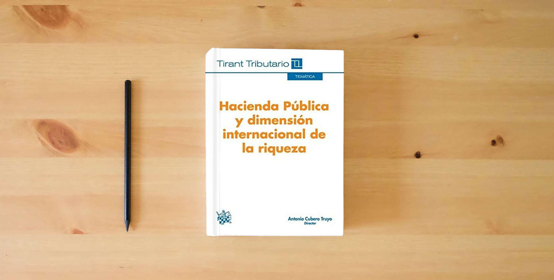 The book Hacienda Pública y Dimensión Internacional de la Riqueza (Temática Tirant Tributario) is on the table