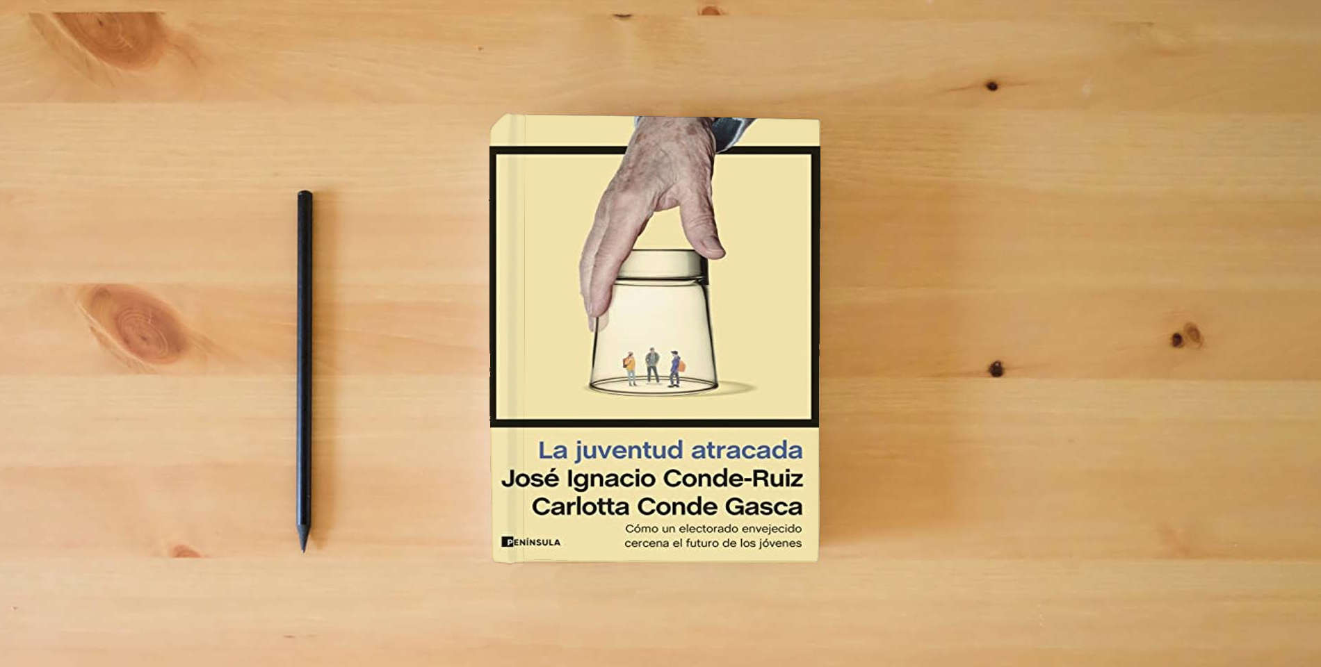The book La juventud atracada: Cómo un electorado envejecido cercena el futuro de los jóvenes (ATALAYA) is on the table