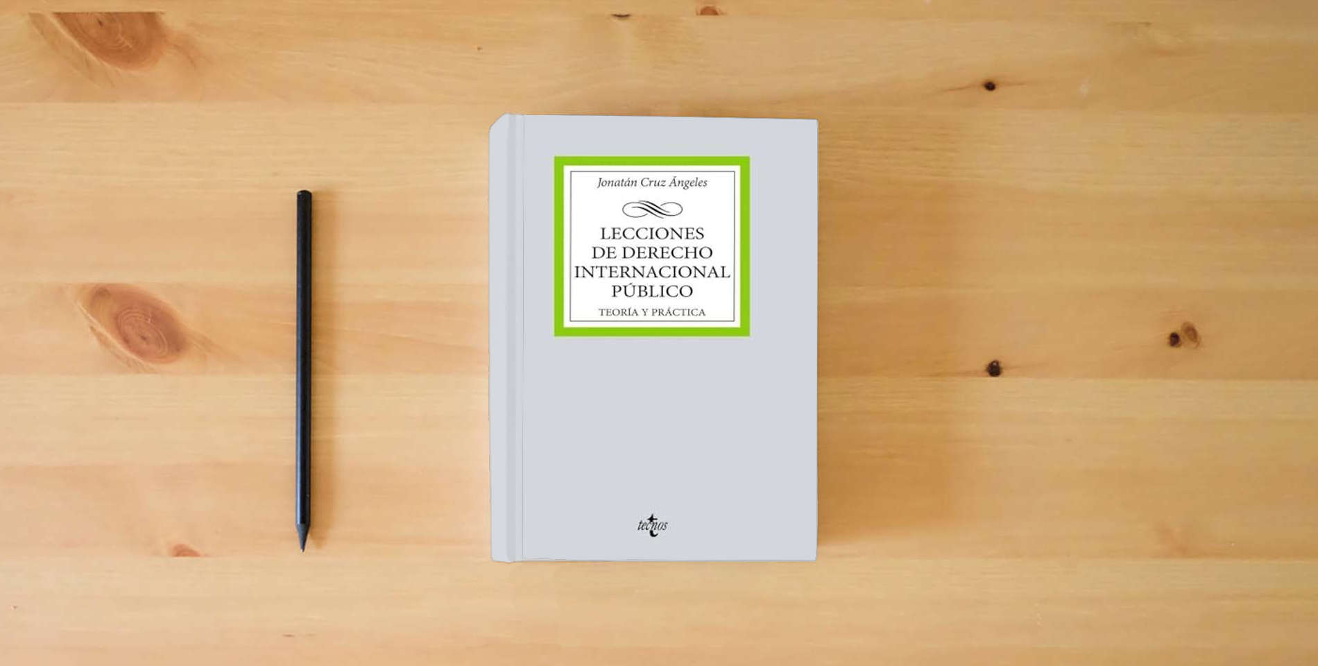 The book Lecciones de Derecho Internacional Público: Teoría y práctica (Derecho - Biblioteca Universitaria de Editorial Tecnos) is on the table