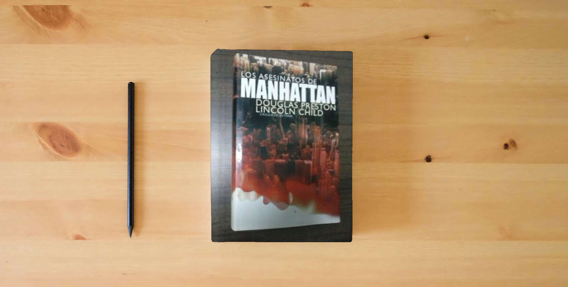The book Los asesinatos de Manhattan is on the table