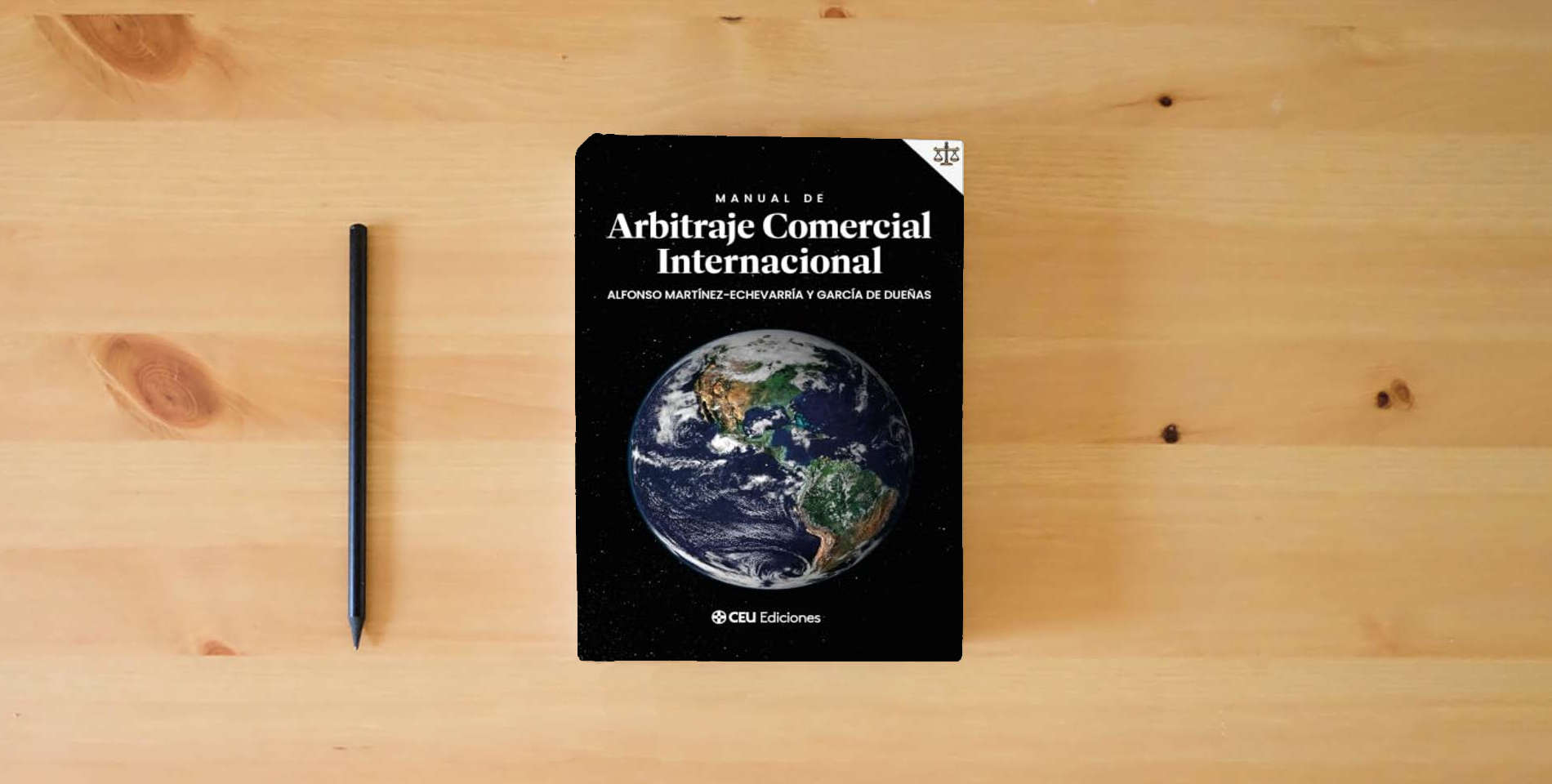 The book Manual De Arbitraje Comercial Internacional: 5 (Derecho) is on the table