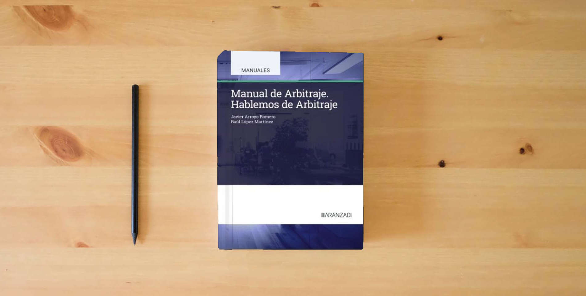 The book Manual de Arbitraje. Hablemos de Arbitraje (Manuales Universitarios) is on the table