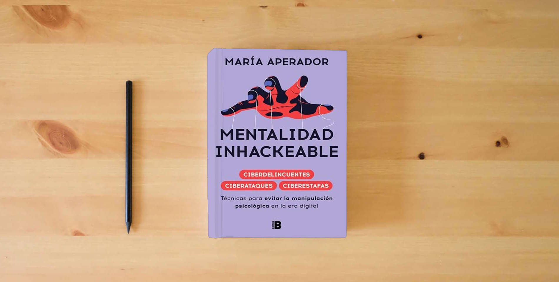 The book Mentalidad inhackeable: Técnicas para evitar la manipulación psicológica en la era digital (Somos B) is on the table
