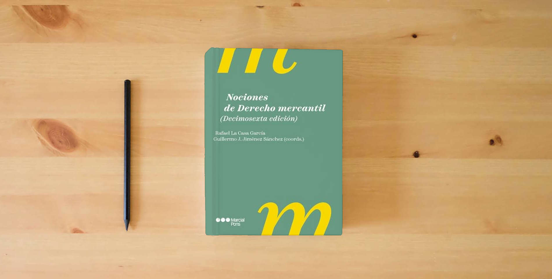 The book Nociones de Derecho mercantil 16.ª ed. (Manuales universitarios) is on the table