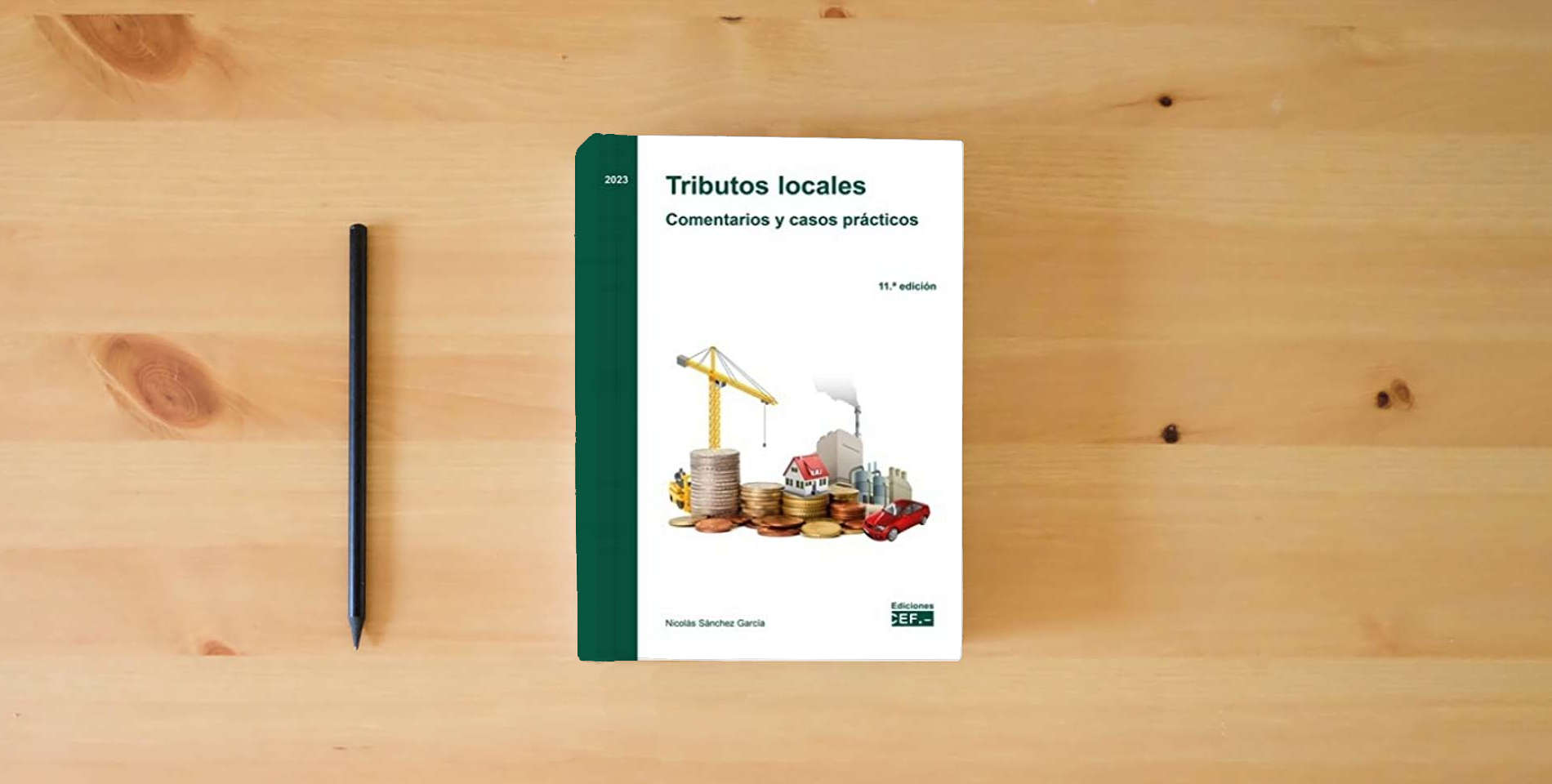 The book Tributos locales. Comentarios y casos prácticos (SIN COLECCION) is on the table