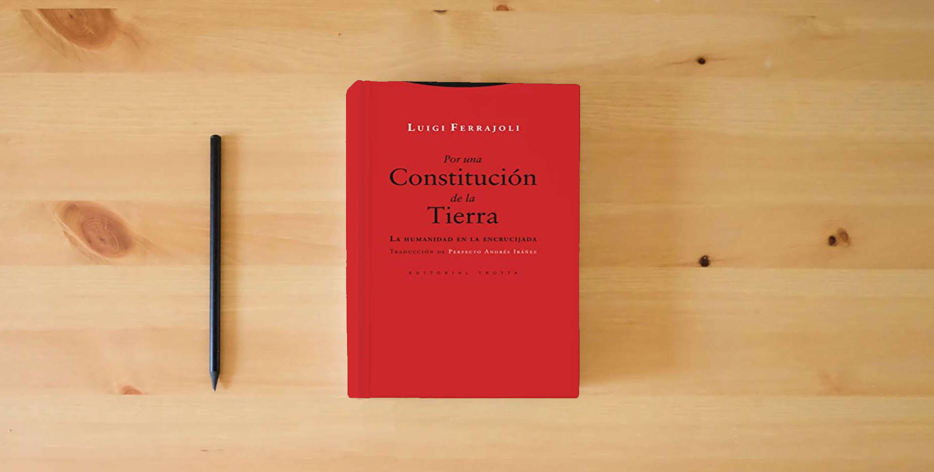 The book Por una Constitución de la Tierra (2ª Ed.): La humanidad en la encrucijada (ESTRUCTURAS Y PROCESOS - DERECHO) is on the table