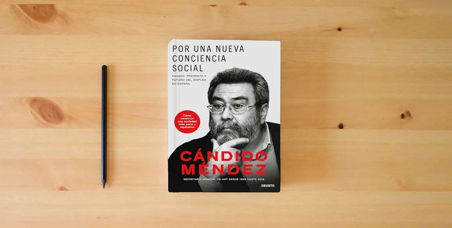 The book Por una nueva conciencia social: Pasado, presente y futuro del empleo en España (Deusto) is on the table