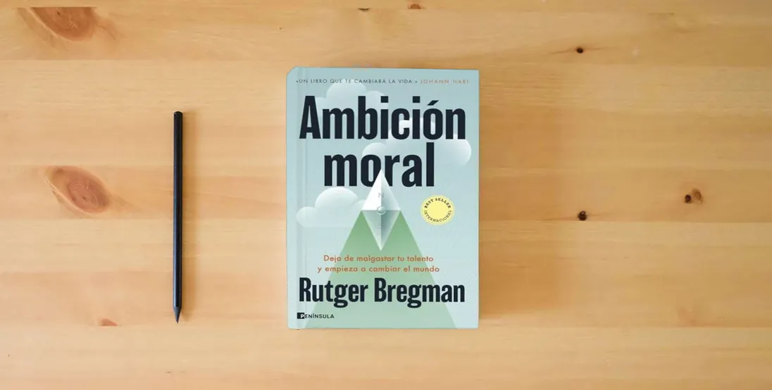 The book Ambición moral: Deja de malgastar tu talento y empieza a cambiar el mundo (PENINSULA)} is on the table