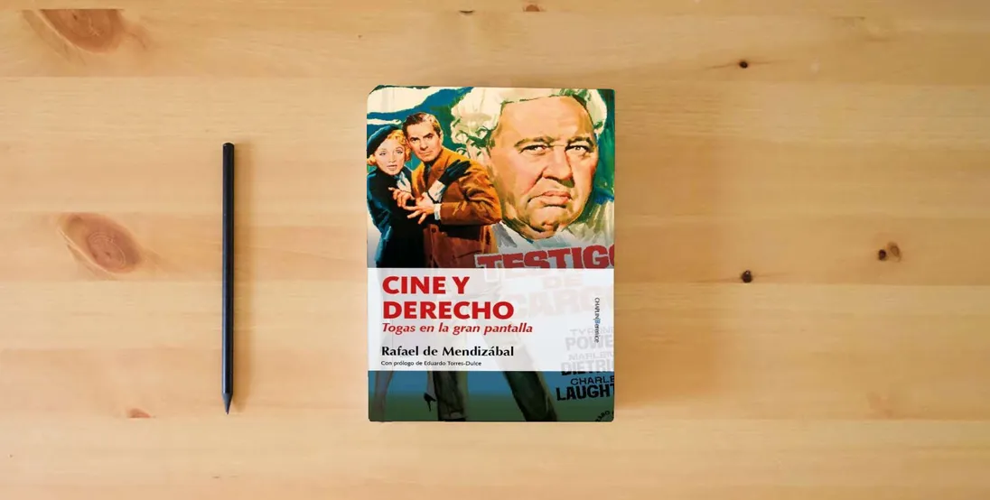 The book Cine y Derecho: Togas en la gran pantalla} is on the table