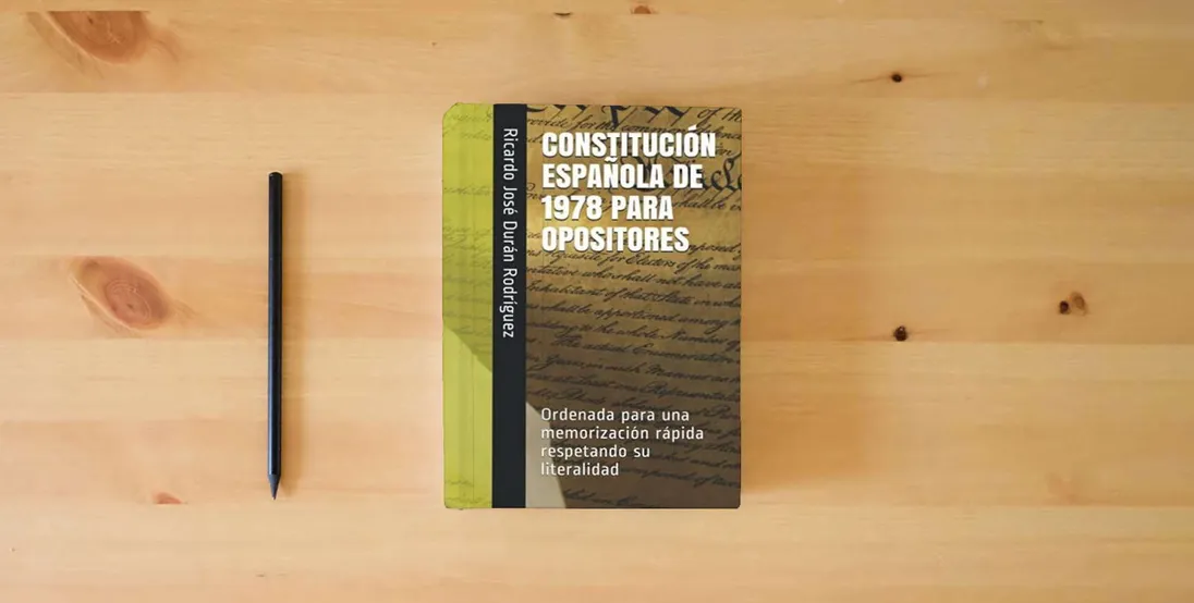 The book CONSTITUCIÓN ESPAÑOLA DE 1978 PARA OPOSITORES: Ordenada para una memorización rápida respetando su literalidad} is on the table