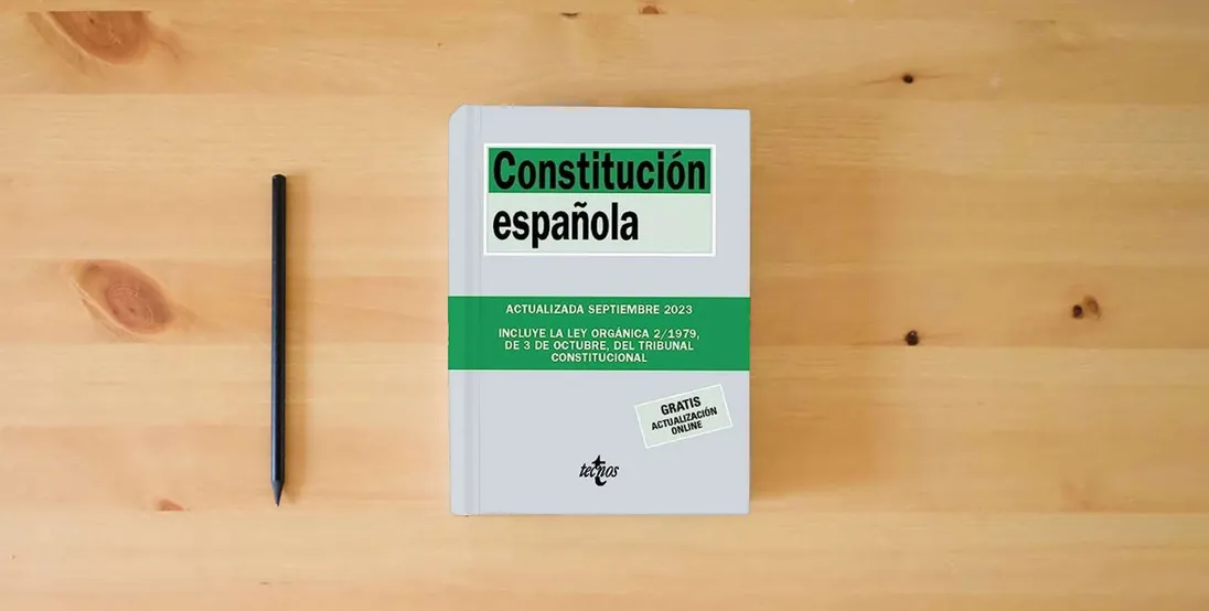 The book Constitución Española (Derecho - Biblioteca de Textos Legales)} is on the table