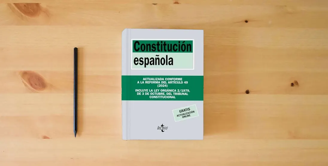 The book Constitución Española (Derecho - Biblioteca de Textos Legales)} is on the table