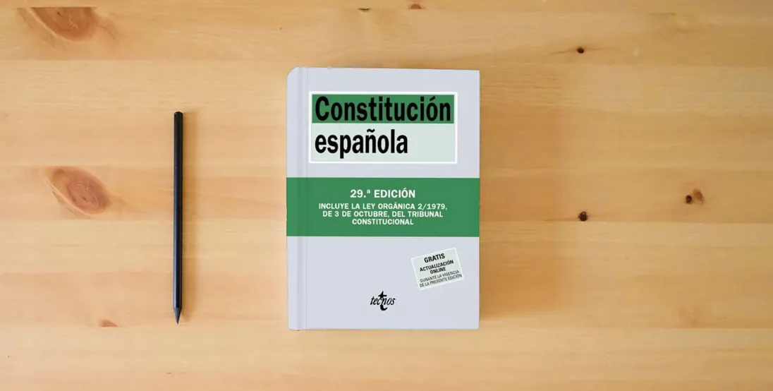 The book Constitución Española (Derecho - Biblioteca de Textos Legales)} is on the table