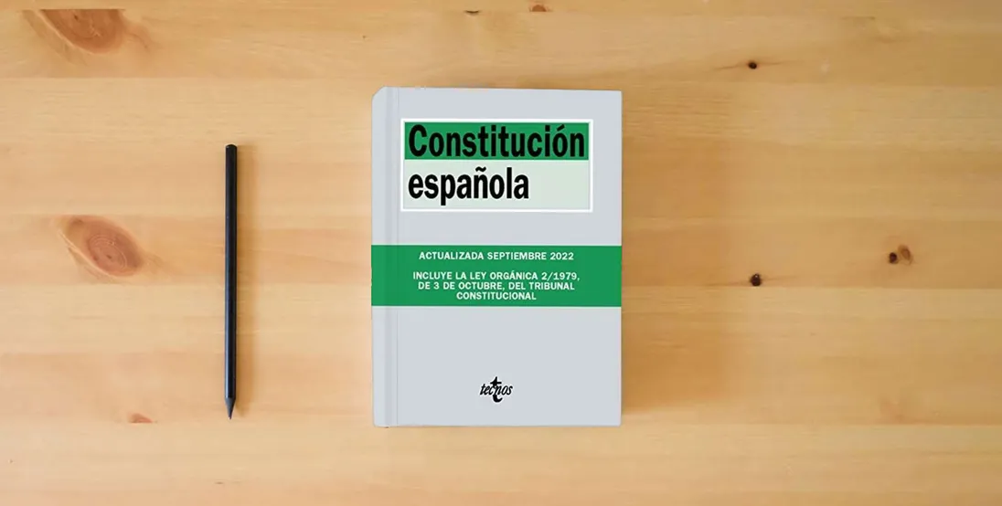 The book Constitución Española (Derecho - Biblioteca de Textos Legales)} is on the table