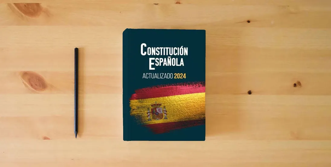 The book CONSTITUCIÓN ESPAÑOLA: Edición actualizada para opositores A4 gran formato} is on the table