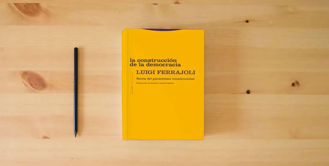 The book La construcción de la democracia: Teoría del garantismo constitucional (ESTRUCTURAS Y PROCESOS - DERECHO)} is on the table