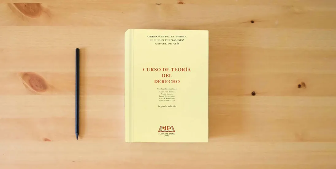 The book Curso De Teoria Del Derecho (Manuales (marcial Pons))} is on the table
