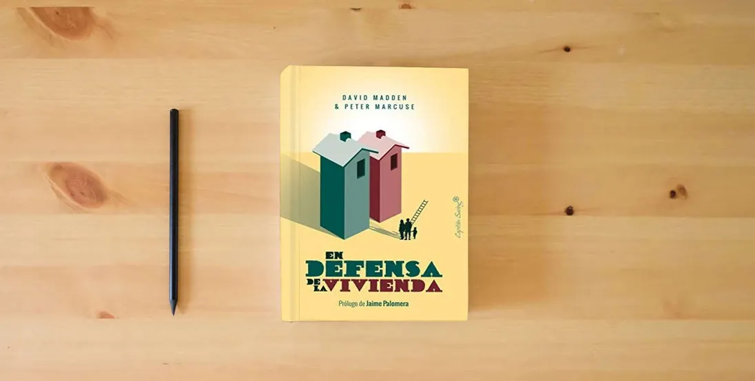 The book En defensa de la vivienda (ENSAYO)} is on the table