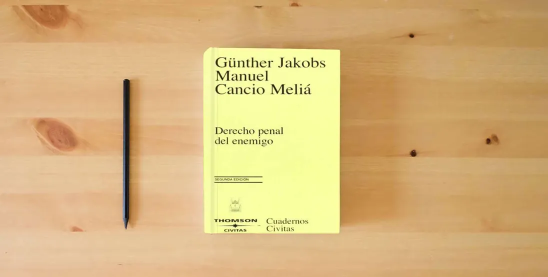 The book Derecho penal del enemigo (Cuadernos)} is on the table