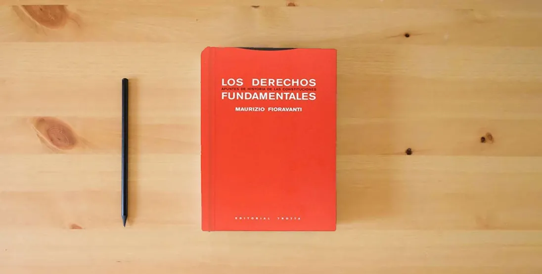 The book Derechos fundamentales: Apuntes de historia de las constituciones (ESTRUCTURAS Y PROCESOS - DERECHO)} is on the table