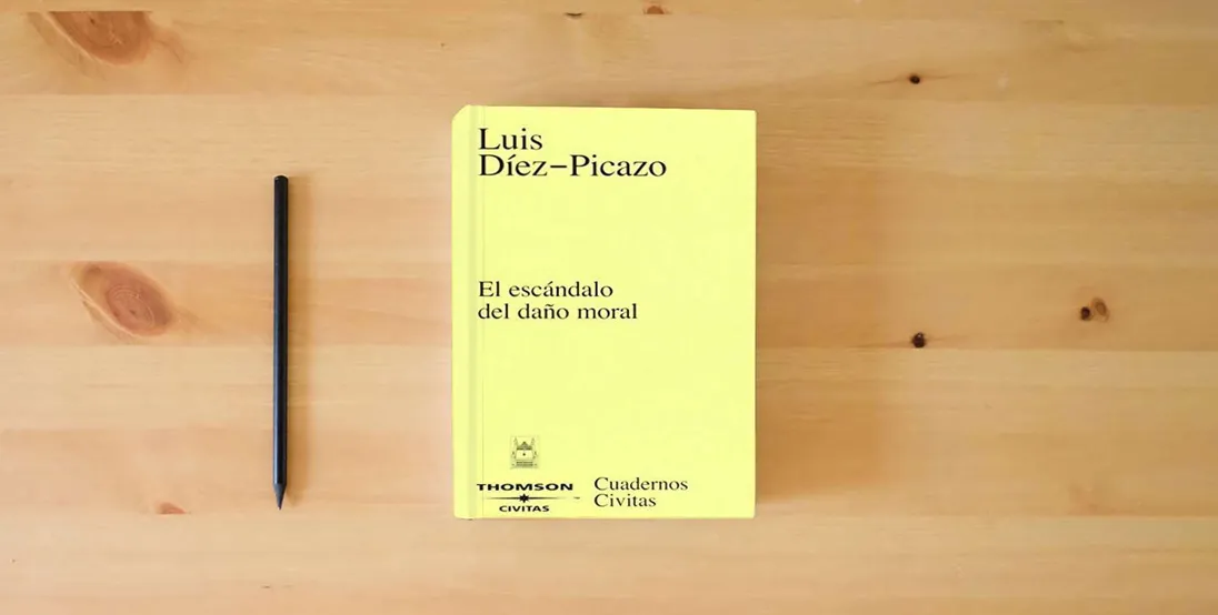 The book El escándalo del daño moral (Cuadernos)} is on the table