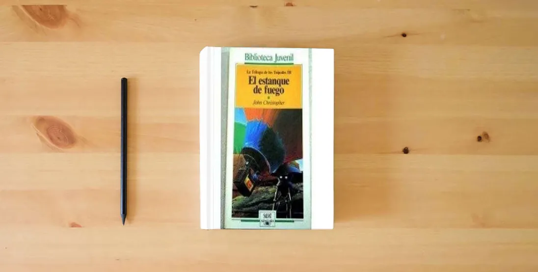 The book Estanque de fuego, el. trilogia de los tripodes III (Alfaguara Juvenil)} is on the table