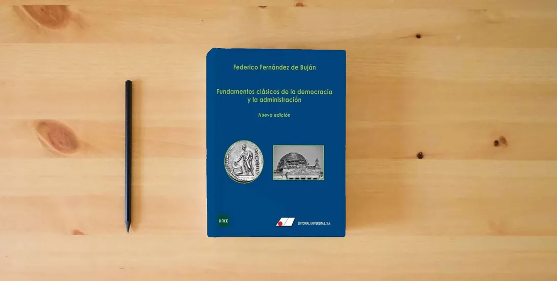 The book Fundamentos clásicos de la democracia y la administración (FONDO)} is on the table
