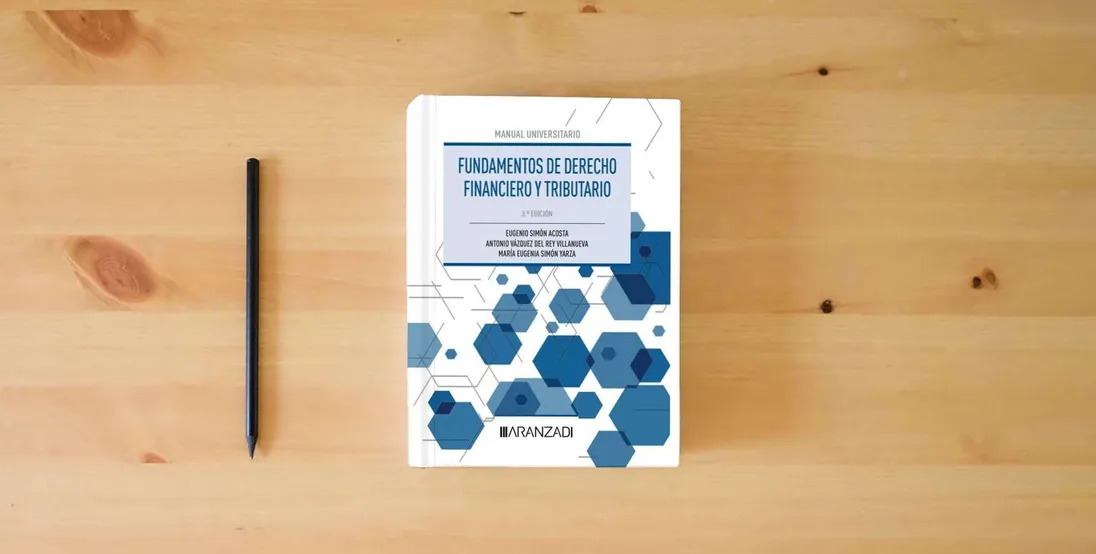 The book Fundamentos de Derecho Financiero y Tributario (Manuales)} is on the table