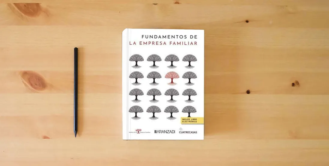 The book Fundamentos de la empresa familiar (Estudios)} is on the table