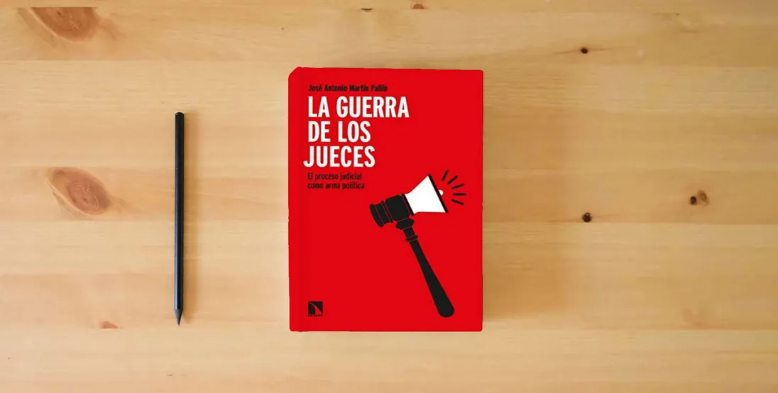 The book La guerra de los jueces: El proceso judicial como arma política: 899 (COLECCION MAYOR)} is on the table