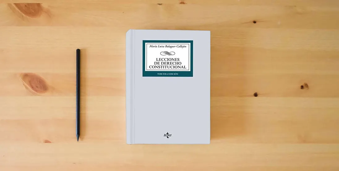 The book Lecciones de Derecho Constitucional (Derecho - Biblioteca Universitaria de Editorial Tecnos)} is on the table