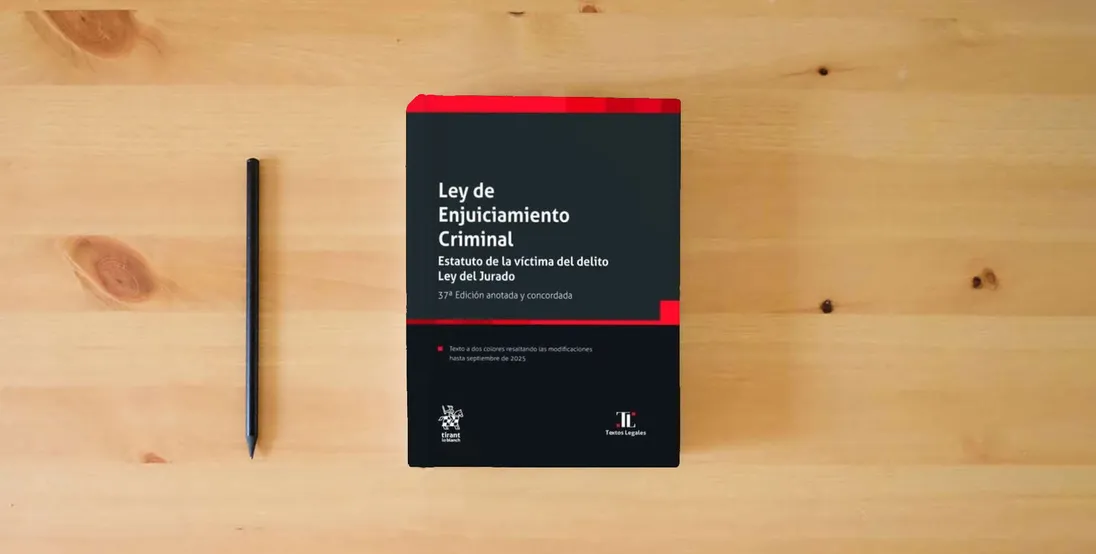 The book Ley de Enjuiciamiento Criminal. Estatuto de la Víctima del Delito. Ley del Jurado. Incluye índice analítico 7ª Edición} is on the table