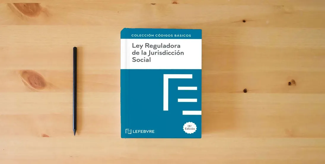 The book Ley Reguladora de la Jurisdicción Social 13ª EDC.: Código Básico (Códigos Básicos)} is on the table