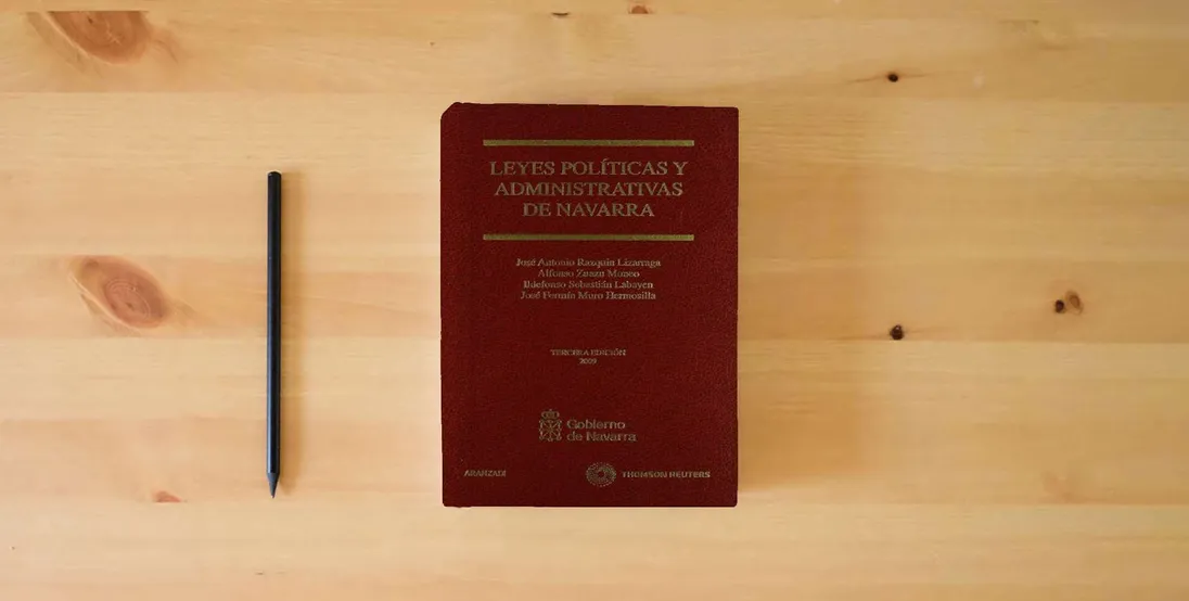 The book Leyes Políticas y Administrativas de Navarra (Código Profesional)} is on the table