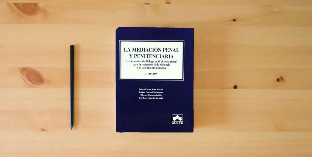 The book Mediacion penal y penitenciaria, la - experiencias de dialogo} is on the table