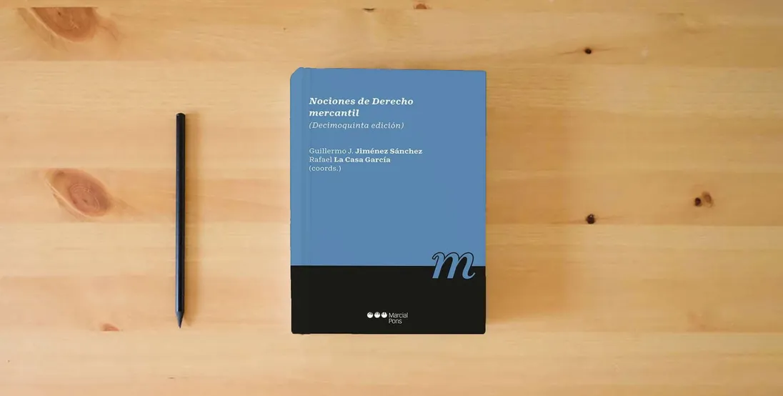 The book Nociones de derecho mercantil: 15ª ed. (Manuales universitarios)} is on the table