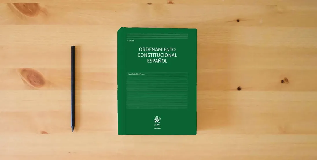 The book Ordenamiento Constitucional Español 3ª Edición: 1 (Manuales de Derecho Constitucional)} is on the table