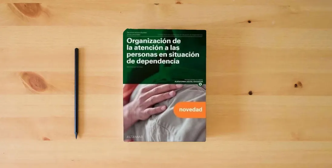 The book Organización de la atención a las personas en situación de dependencia. Nueva edición (CFGM ATENCIÓN A PERSONAS EN SITUACIÓN DE DEPENDENC)} is on the table