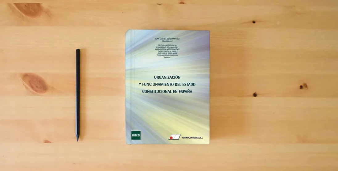 The book Organización y funcionamiento del estado constitucional en España (FONDO)} is on the table