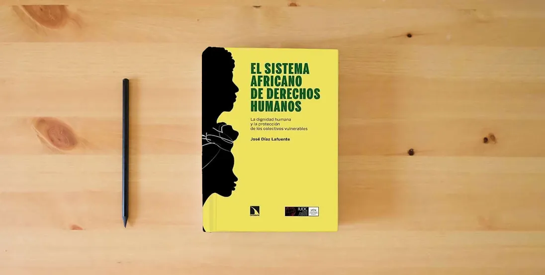 The book El sistema africano de derechos humanos: La dignidad humana y la protección de los colectivos vulnerables: 954 (COLECCION MAYOR)} is on the table