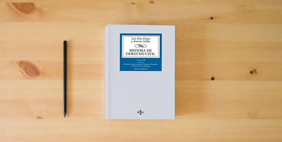 The book Sistema de Derecho civil: Volumen III (Tomo 1) Derechos Reales en general (Derecho - Biblioteca Universitaria de Editorial Tecnos)} is on the table