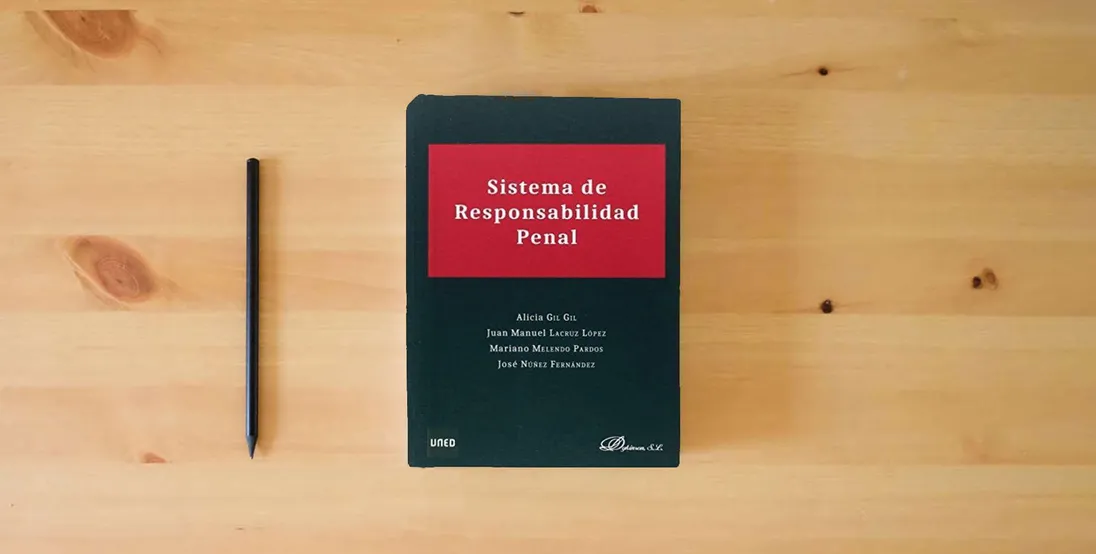 The book Sistema de responsabilidad penal (SIN COLECCION)} is on the table